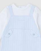 Detailfoto Tutto Piccolo lichtblauw baby tuinpak jongens - borststuk met Tutto Piccolo logo en decoratieve zakjes met knopen
