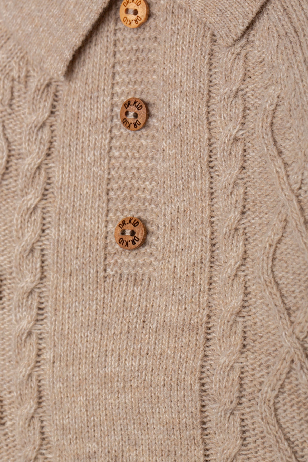 Detailopname kabelpatroon en houten Dr. Kid knoopjes babypakje DK146.
