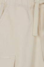  Detail van de ecru stof, het strikkoord en een cargozak van de Dr. Kid broek