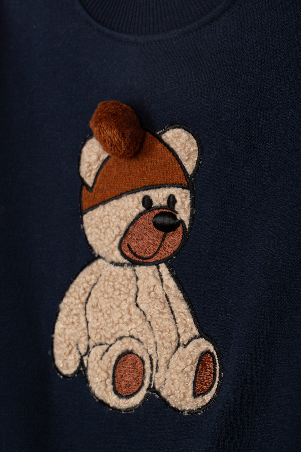 geborduurd teddybeer detail met pompommuts