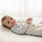 Pasgeboren baby liggend in lichtblauwe onesie met voertuig print – MATTY Sofija geboorteset