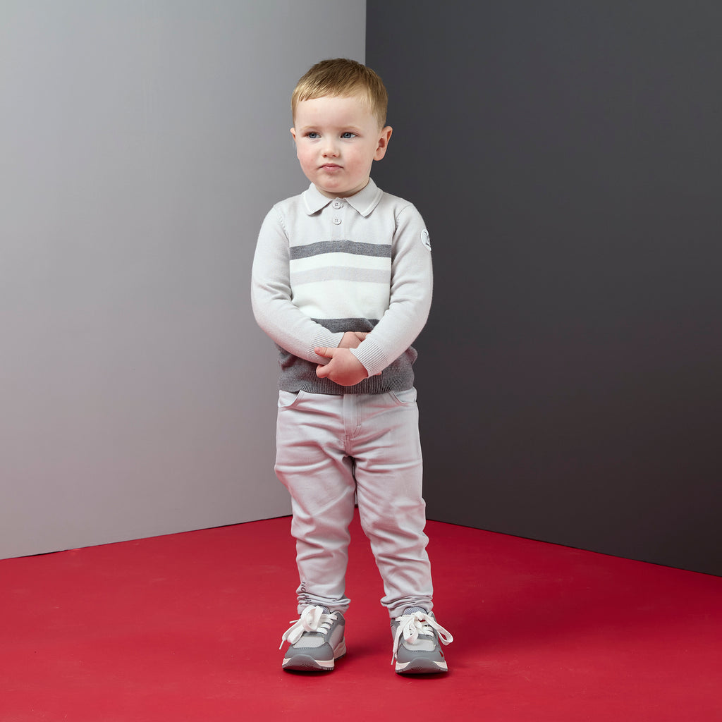 Peuter in lichtgrijze Mitch & Son Trace broek gecombineerd met gestreepte polo en sneakers