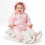 Baby meisje in roze gewatteerde snowsuit met ruches capuchon en strik