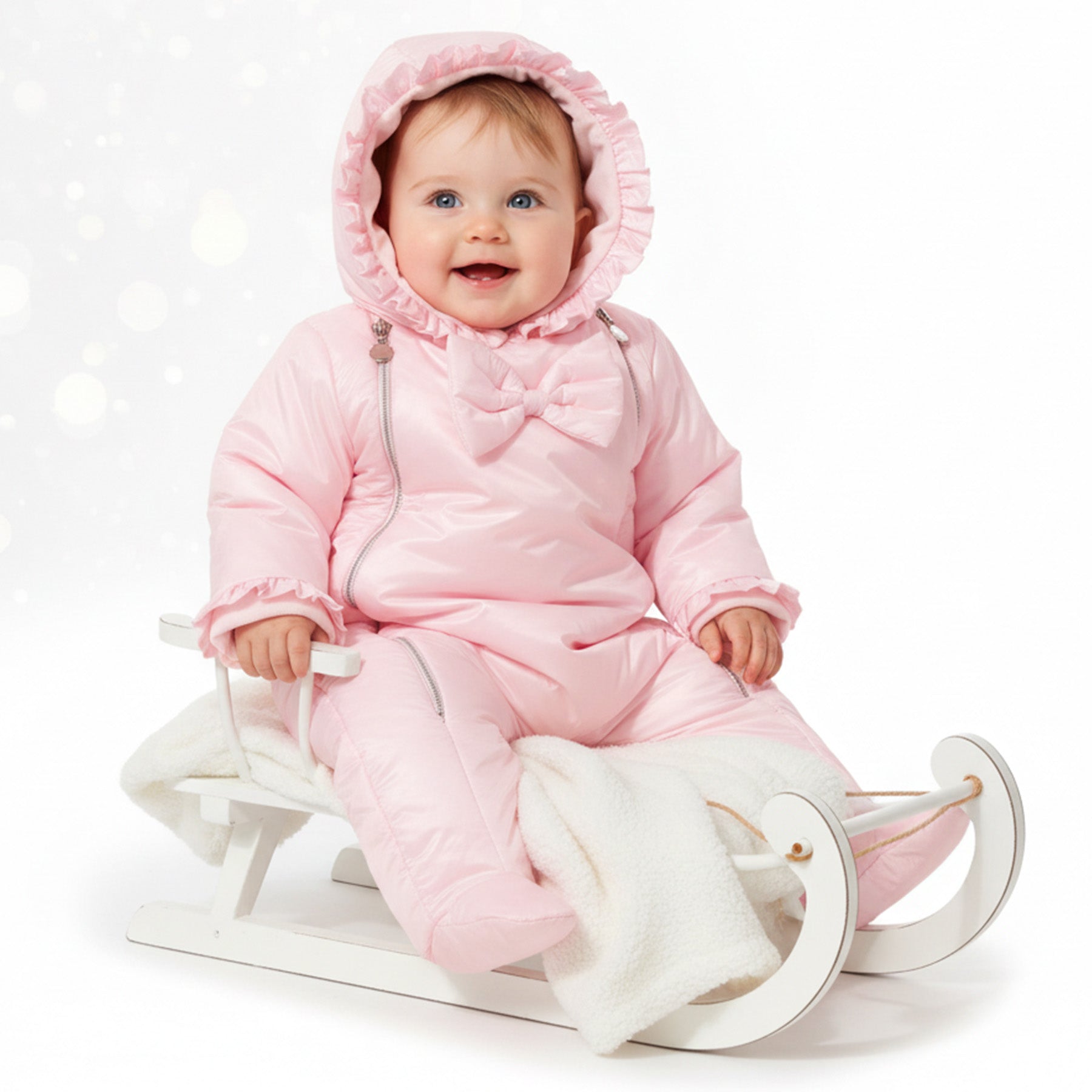 Baby meisje in roze gewatteerde snowsuit met ruches capuchon en strik